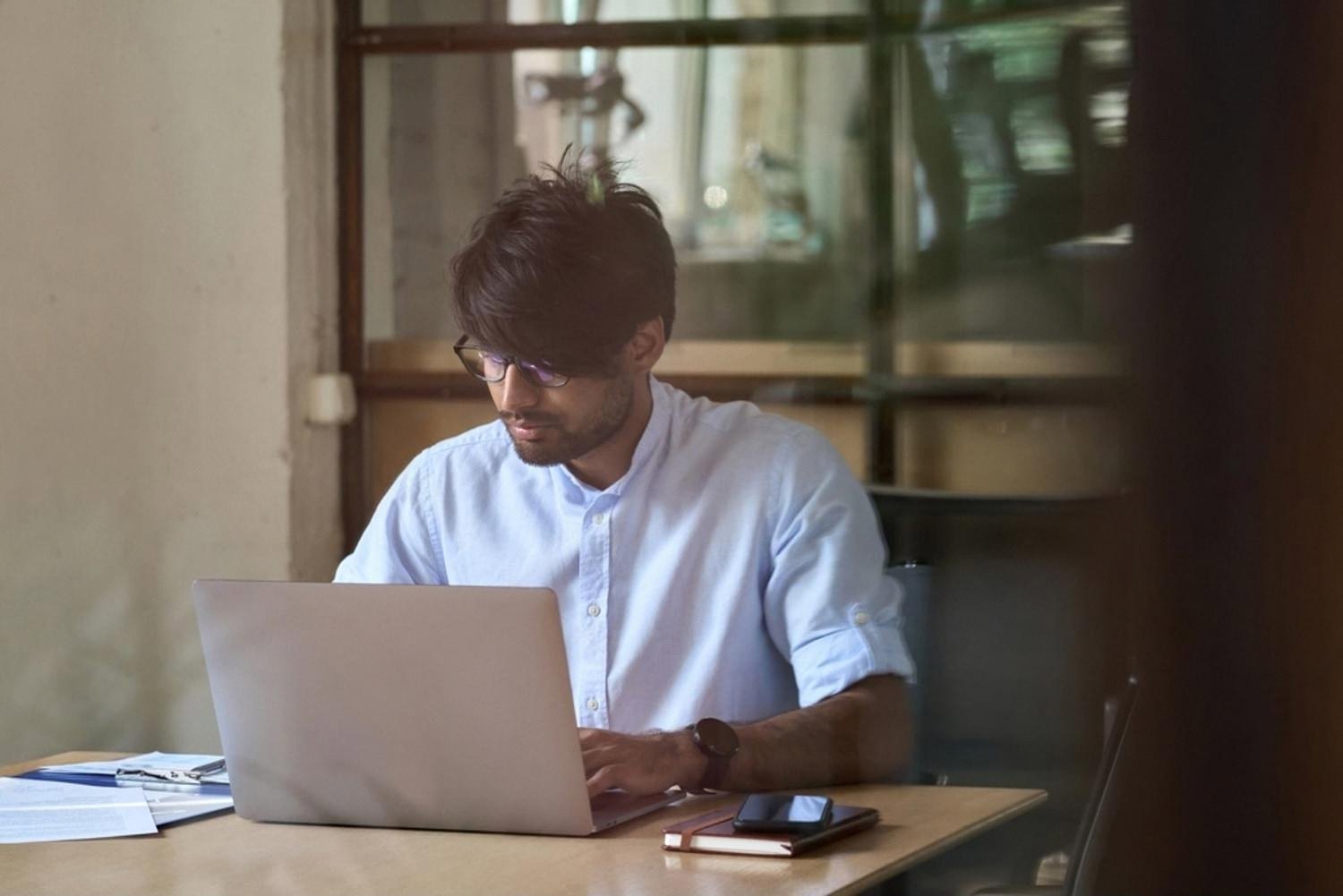 Man at a laptop checking whether a domain name is available for his UAE business